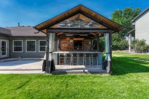 Covered back patio with built in bar and outdoor entertaining space at 7170 Windwood Way Parker CO