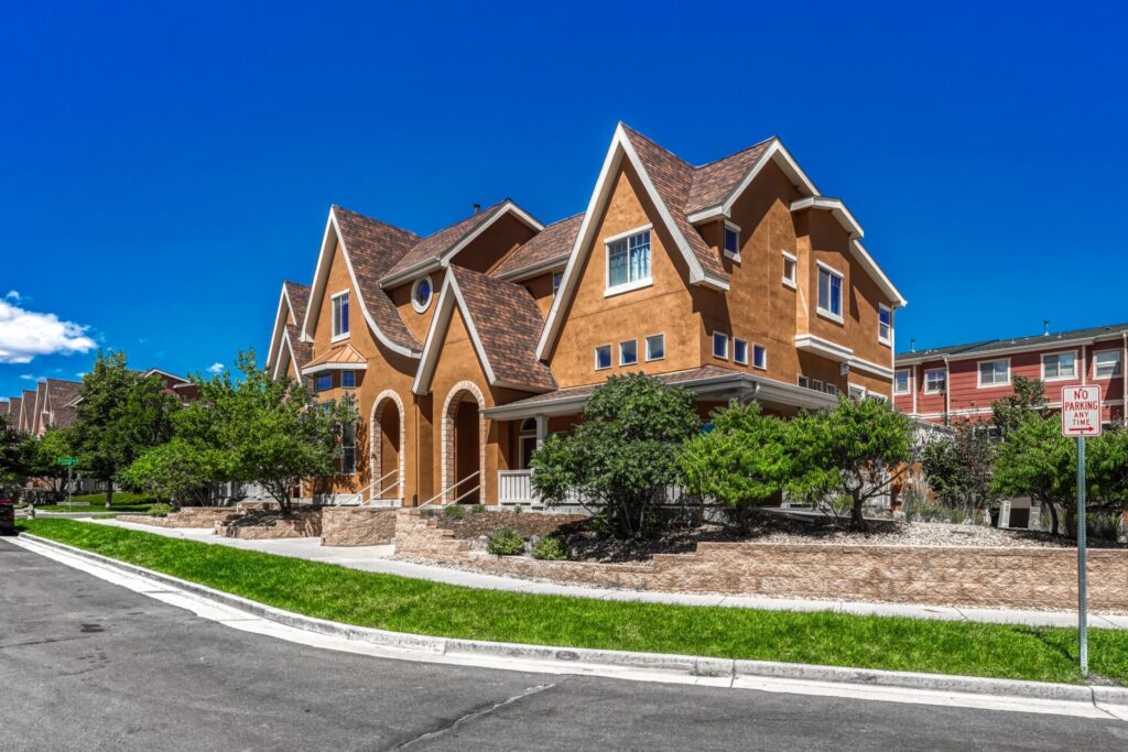End-unit townhome at 18317 E Saskatoon Place in Anthology, Parker Colorado, with a wraparound front porch.